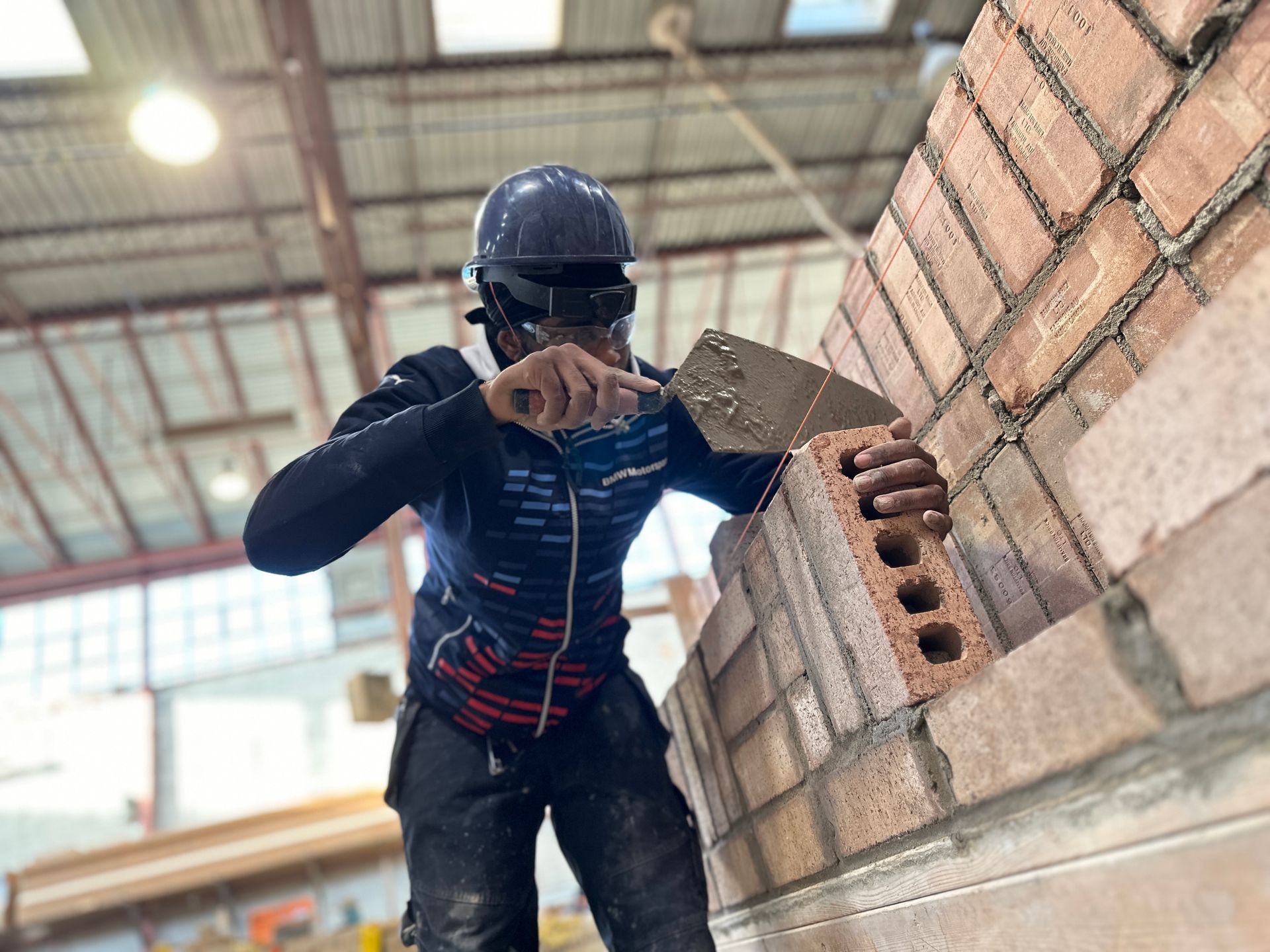 a group of construction workers are working on a brick wall