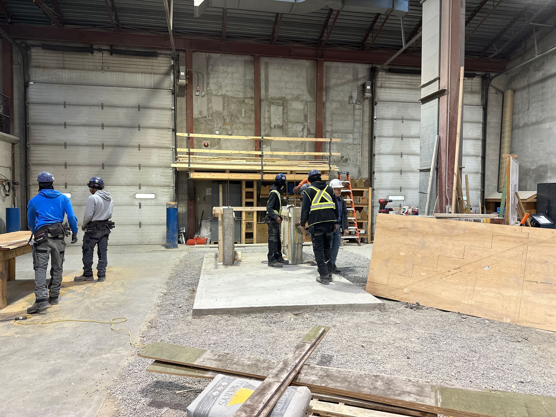 a group of construction workers are standing in a warehouse