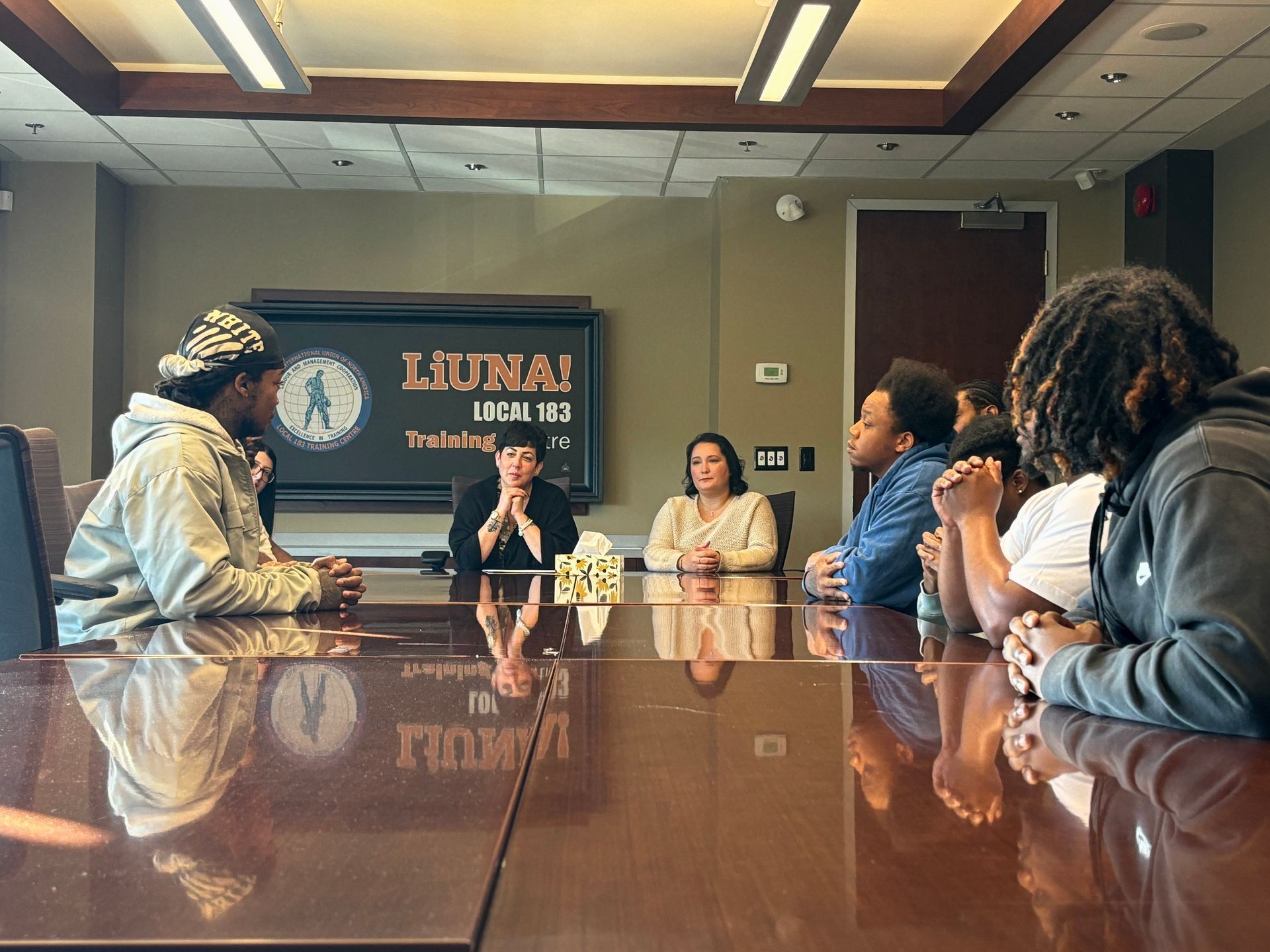 A group of people are sitting around a conference table