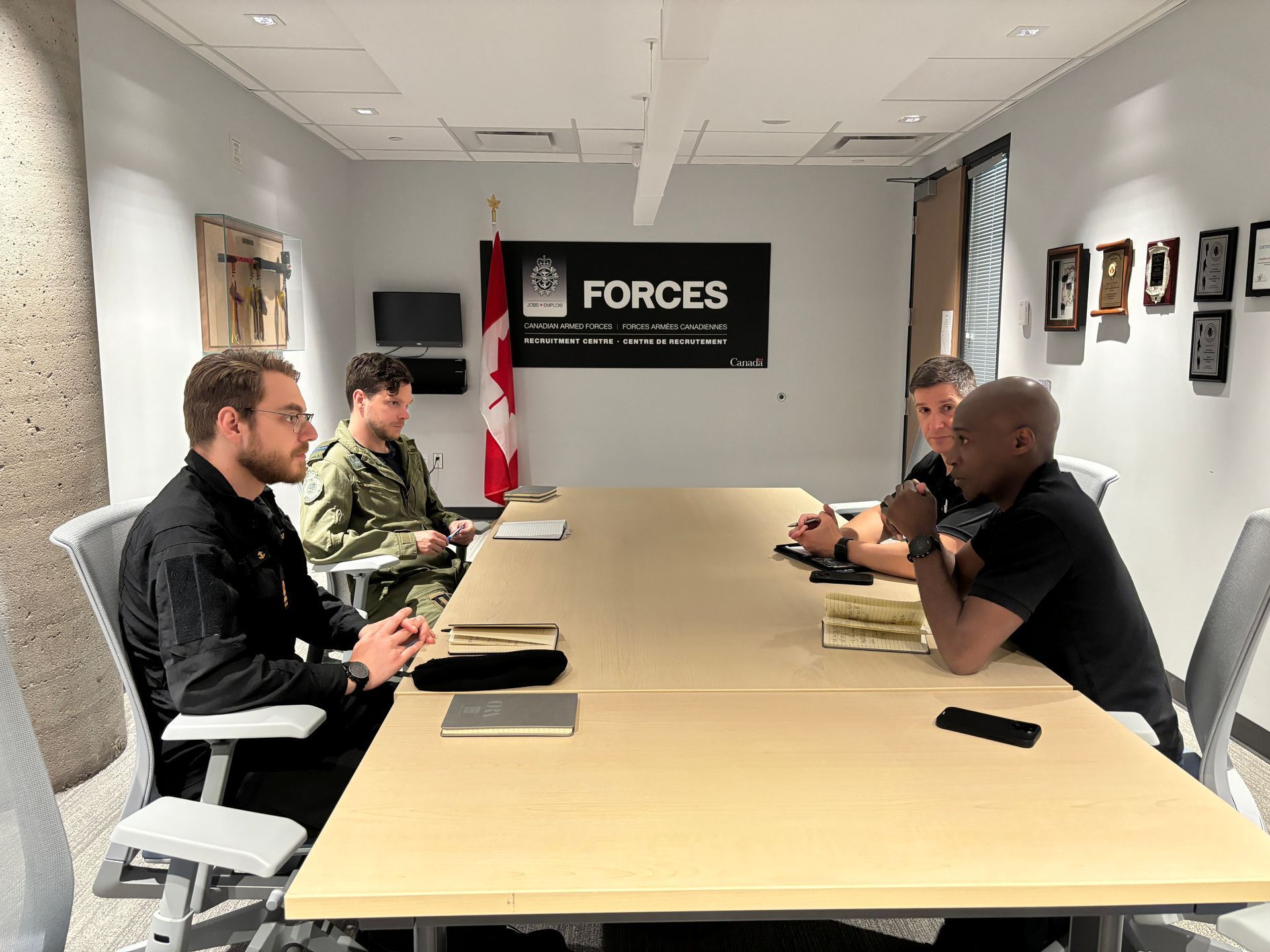 A group of men are sitting around a table in a conference room.