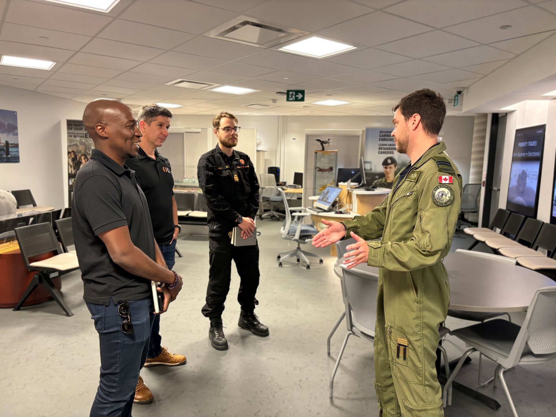 A man in a military uniform is talking to a group of men in a room.