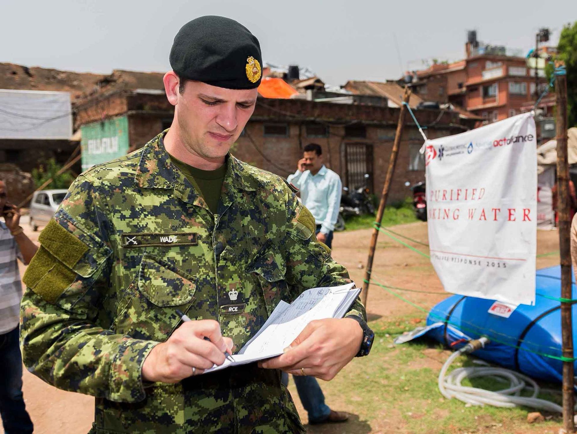 A man in a military uniform is writing on a piece of paper