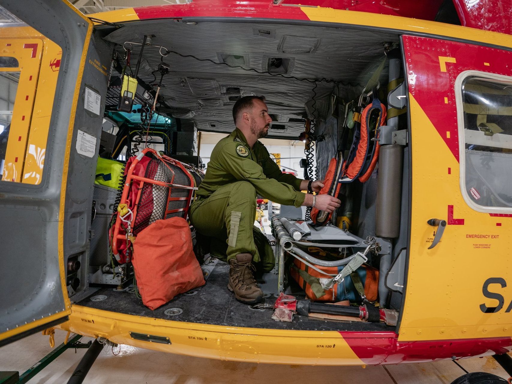 A man is sitting in the cockpit of a helicopter.