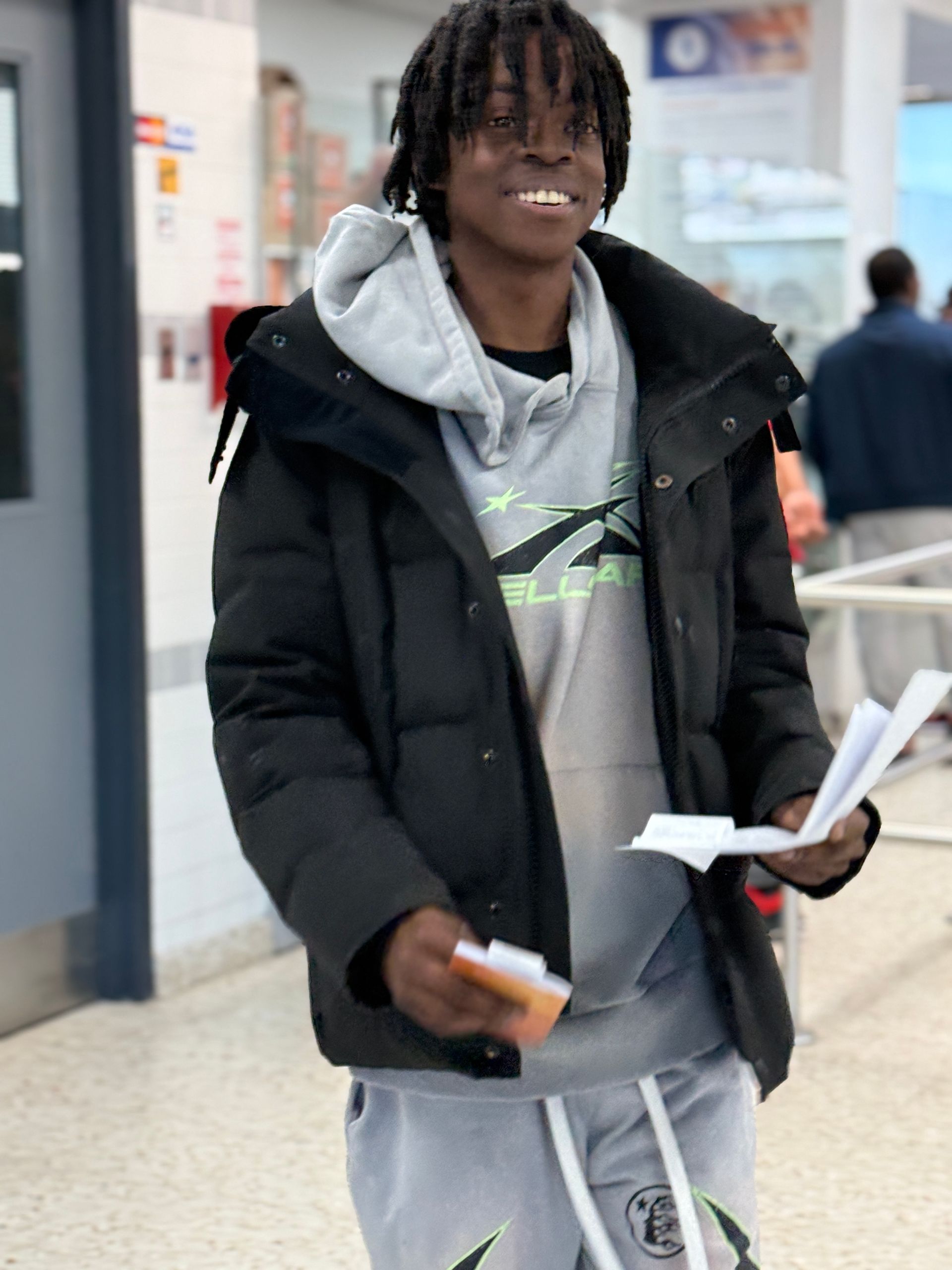 A man in a black jacket is holding a piece of paper