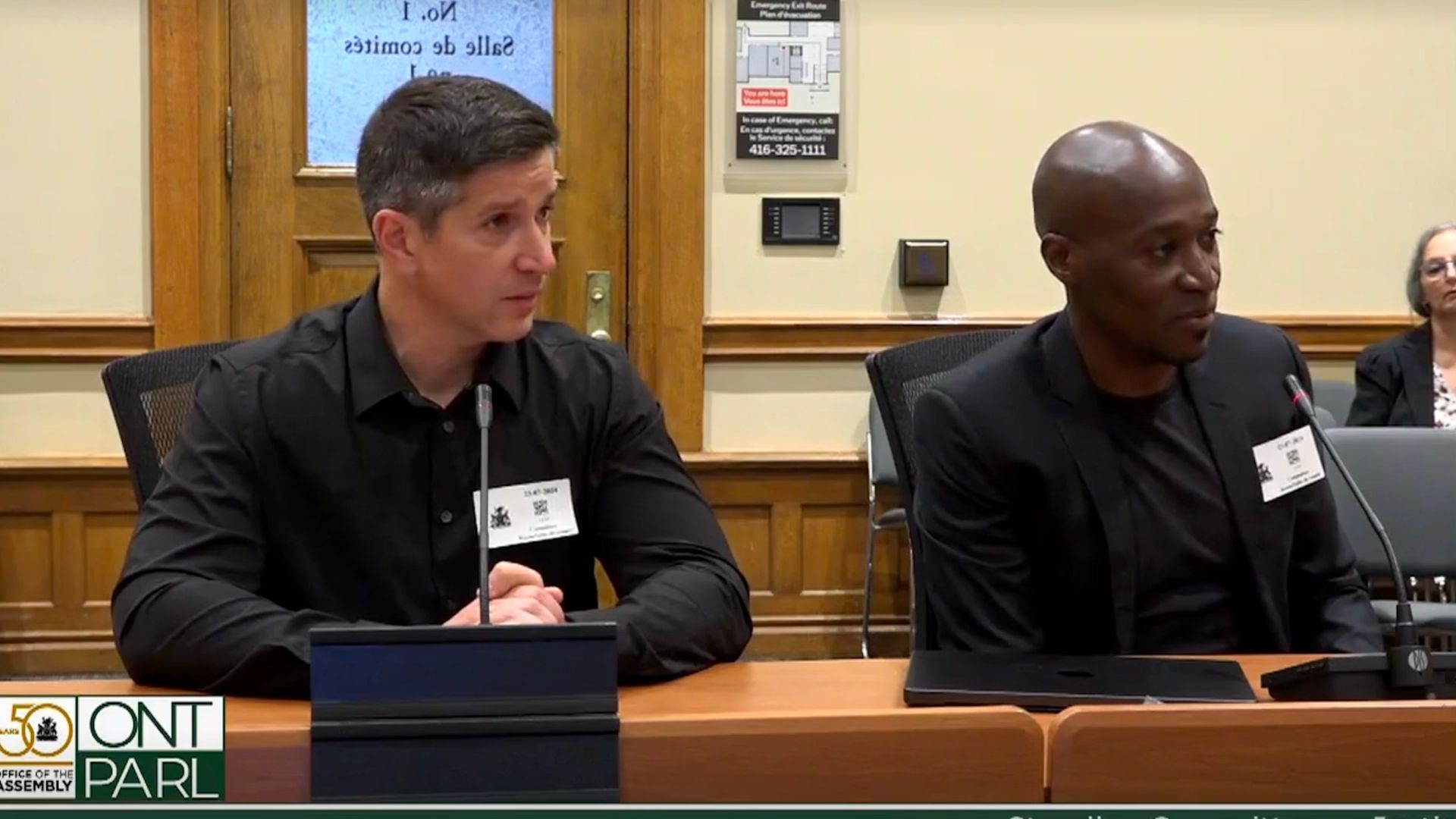 Mark and Joe sitting at a table in front of microphones.