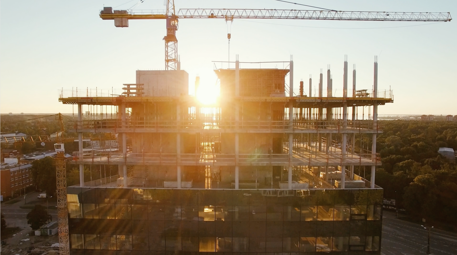 The sun is shining through the windows of a building under construction.