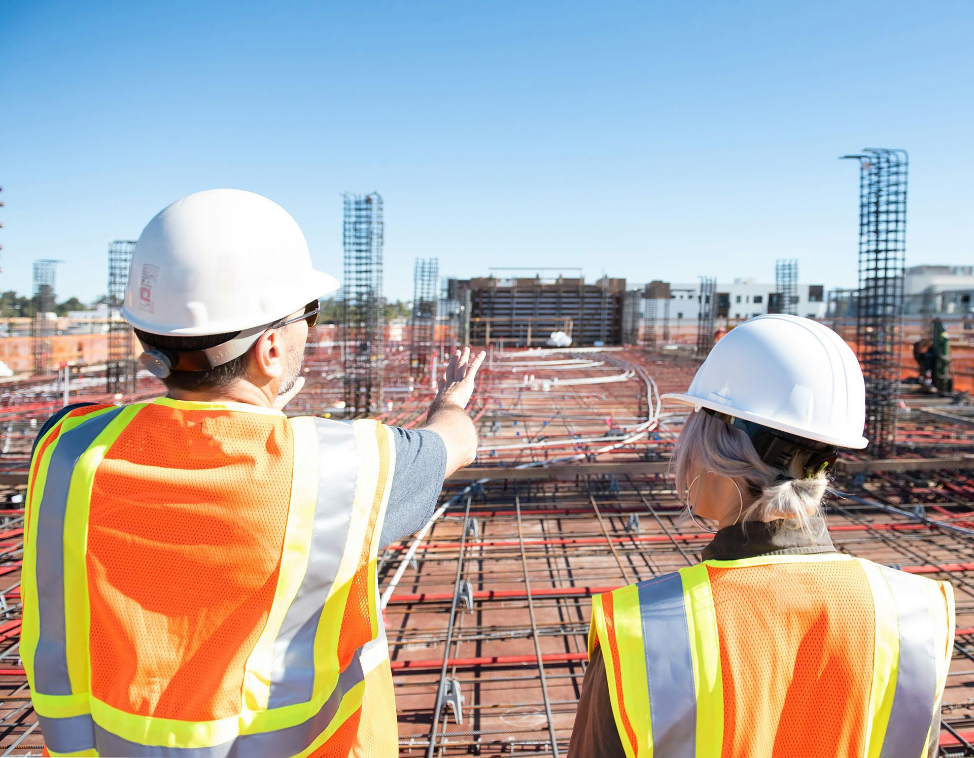 A man and a woman are looking at a construction site.