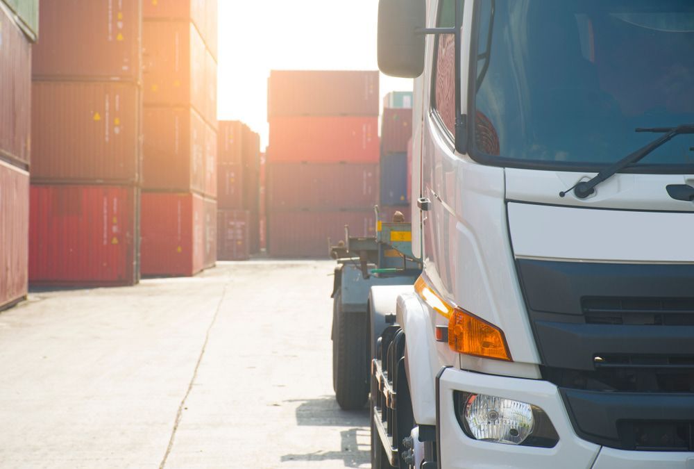 A White Truck is Parked in a Warehouse With Containers in the Background — Mareeba Express Towing in Mareeba, QLD