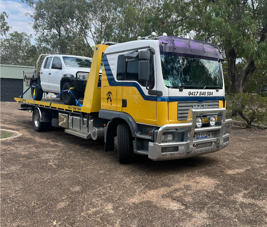 A Yellow and White Tow Truck is Parked in the Grass — Mareeba Express Towing in Atherton, QLD