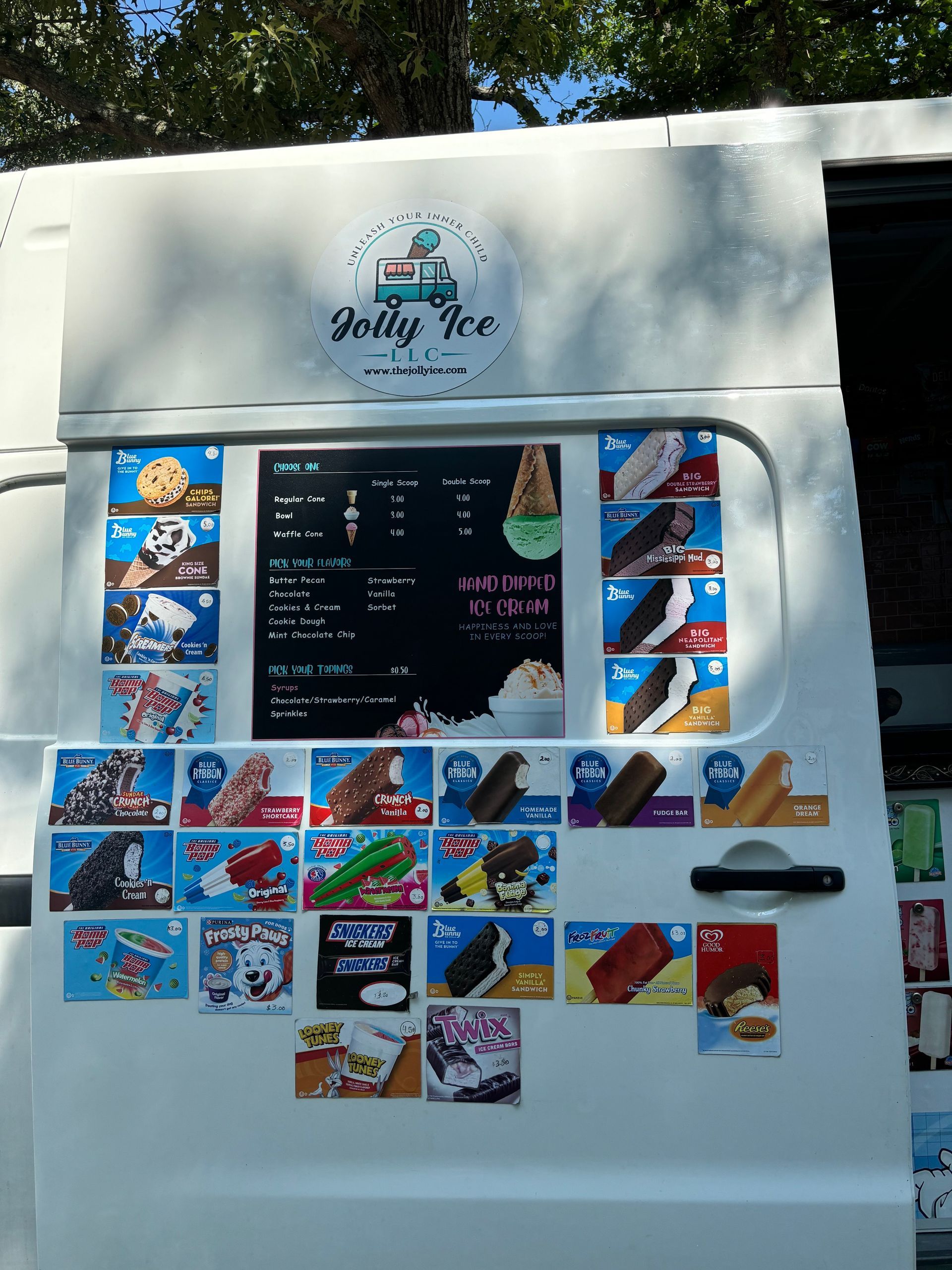 A white ice cream truck with a menu on the door