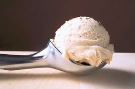 A scoop of ice cream is sitting on a table.