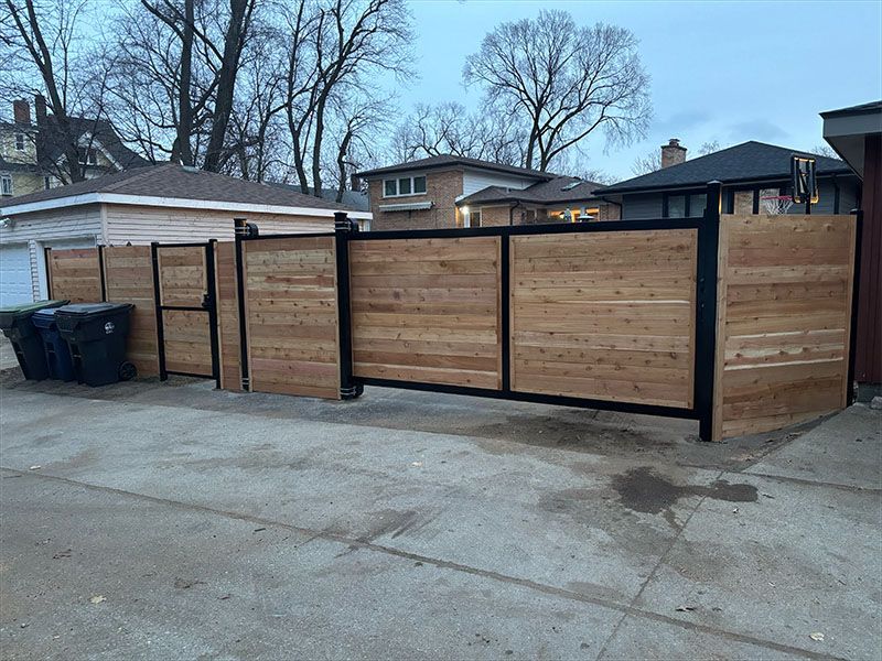 A wooden fence is sitting in front of a house.