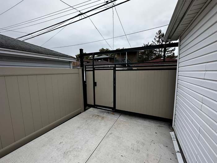 A white house with a fence and a gate in the backyard