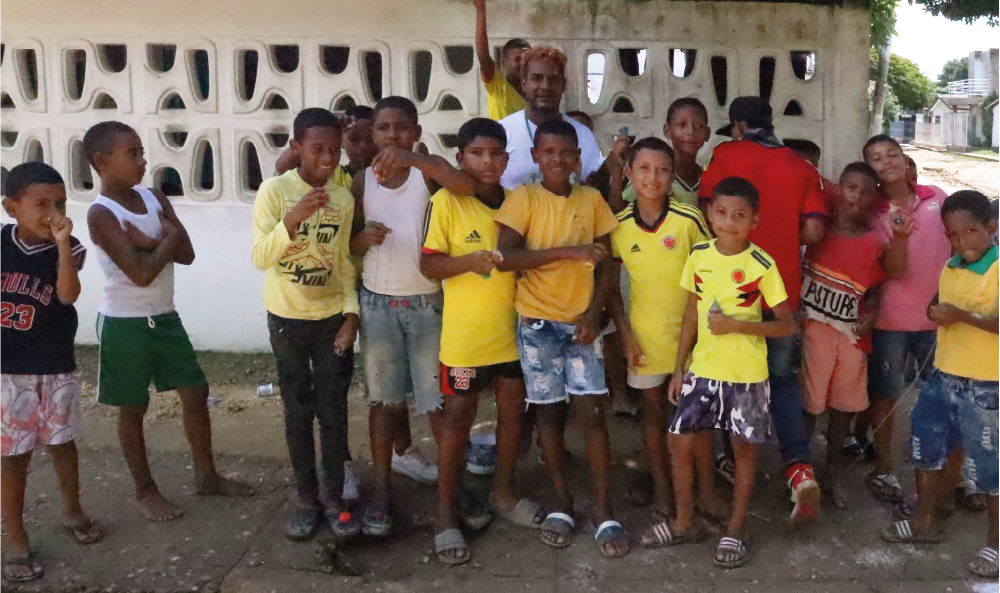 Un grupo de niños posa para una foto frente a una pared.