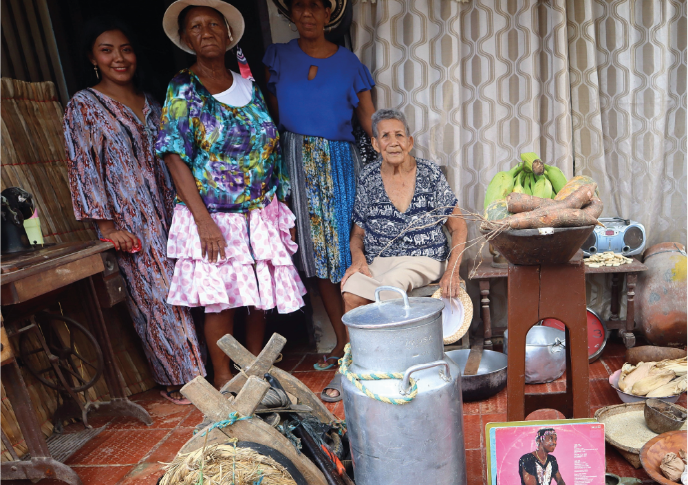 Un grupo de mujeres posa para una fotografía delante de macetas.