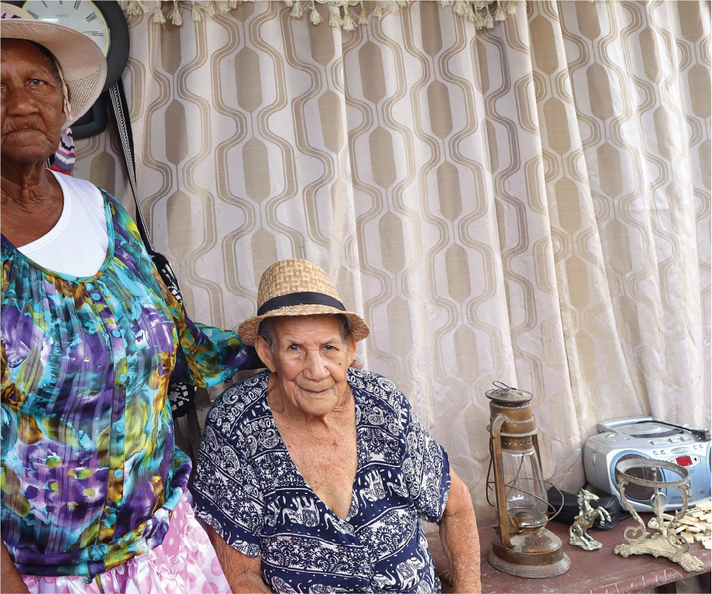 Dos mujeres posan para una foto delante de una cortina.