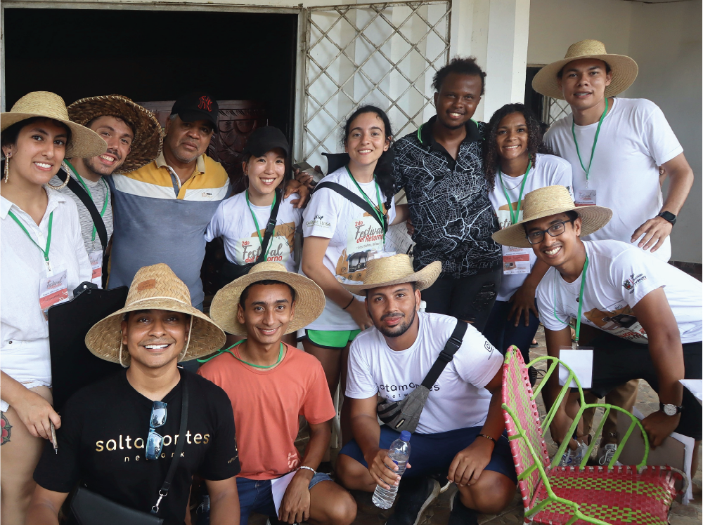 Un grupo de personas con sombreros de paja posan para una fotografía.