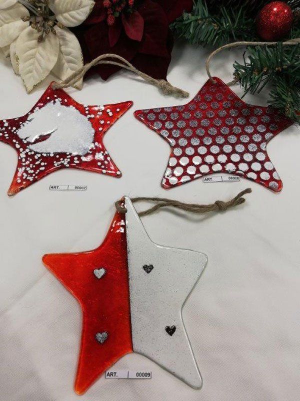 Tre decorazioni natalizie a forma di stella rossa e bianca con motivi diversi e ganci in spago.