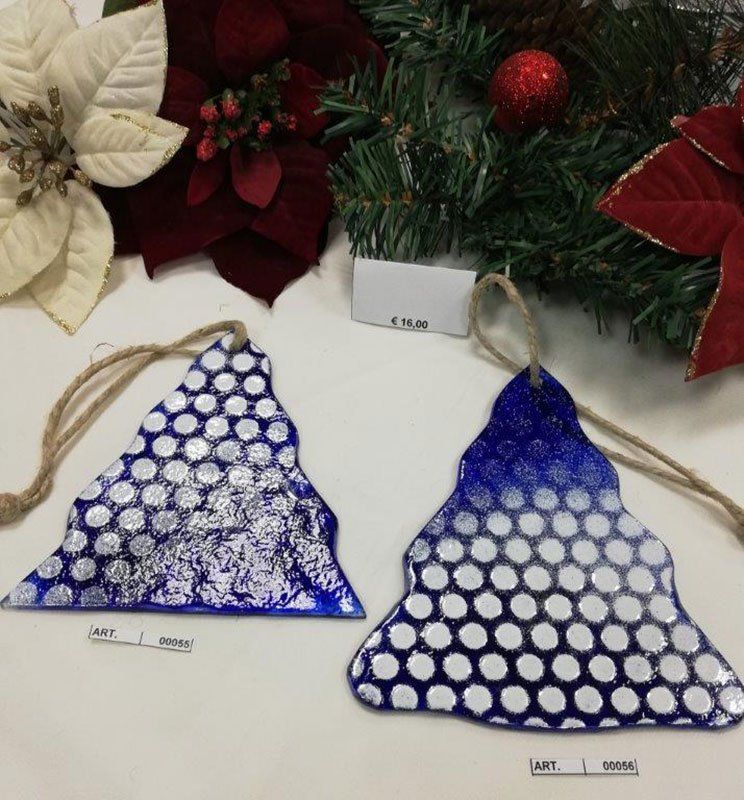 Due decorazioni natalizie blu con pois bianchi su una superficie bianca con decorazioni.