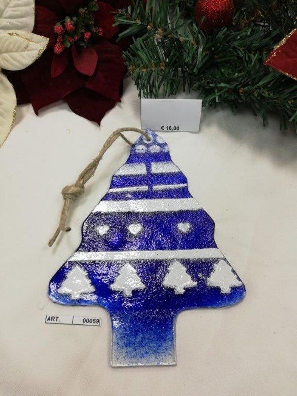 Decorazione per albero di Natale blu e bianca con spago di iuta, sullo sfondo di verde festivo e una stella di Natale.