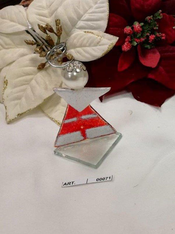 Ornamento in vetro artistico a forma di angelo con accenti rossi e bianchi, davanti a stelle di Natale.
