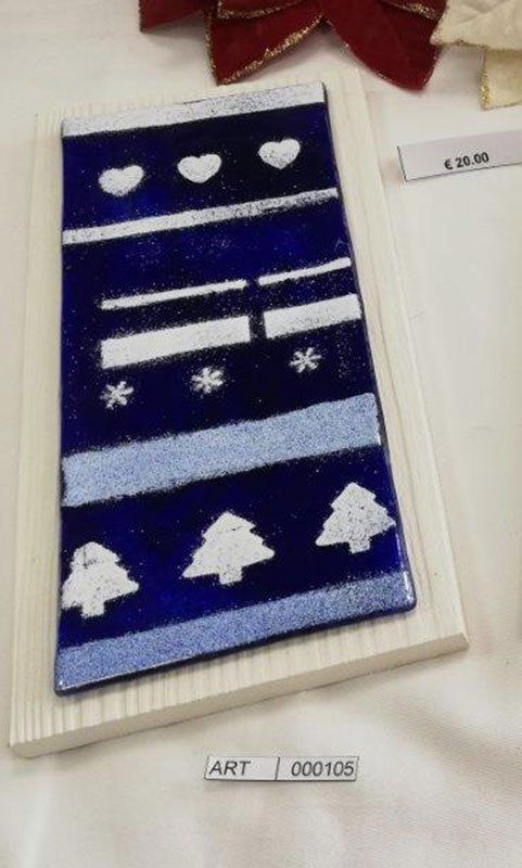 Decorazione natalizia blu e bianca su base di legno bianca; include cuori, strisce, fiocchi di neve e alberi.