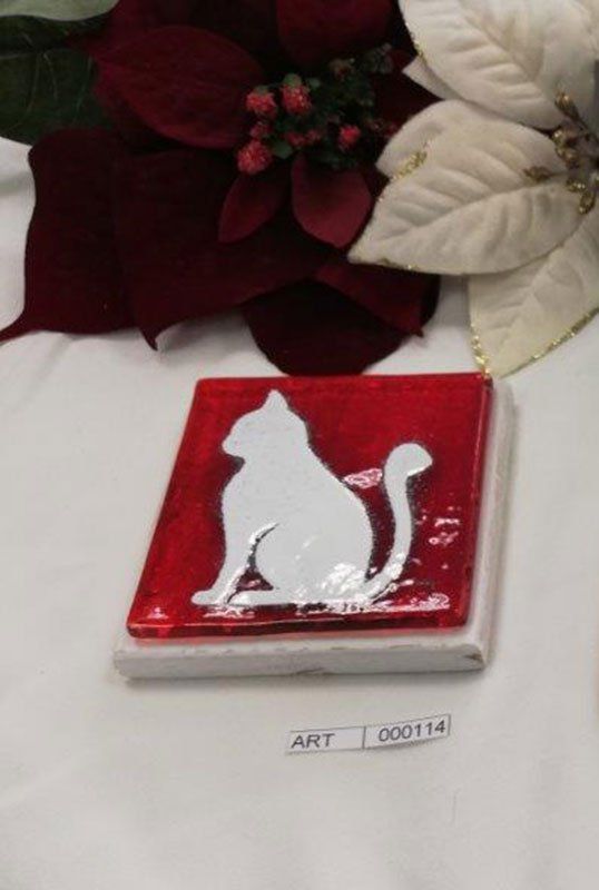 Decorazione a forma di gatto rosso e bianco con stelle di Natale sullo sfondo.