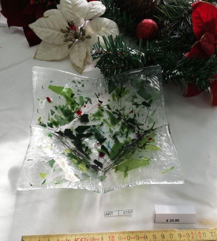 Piatto quadrato in vetro con dettagli verdi e rossi, in contrasto con le decorazioni natalizie.