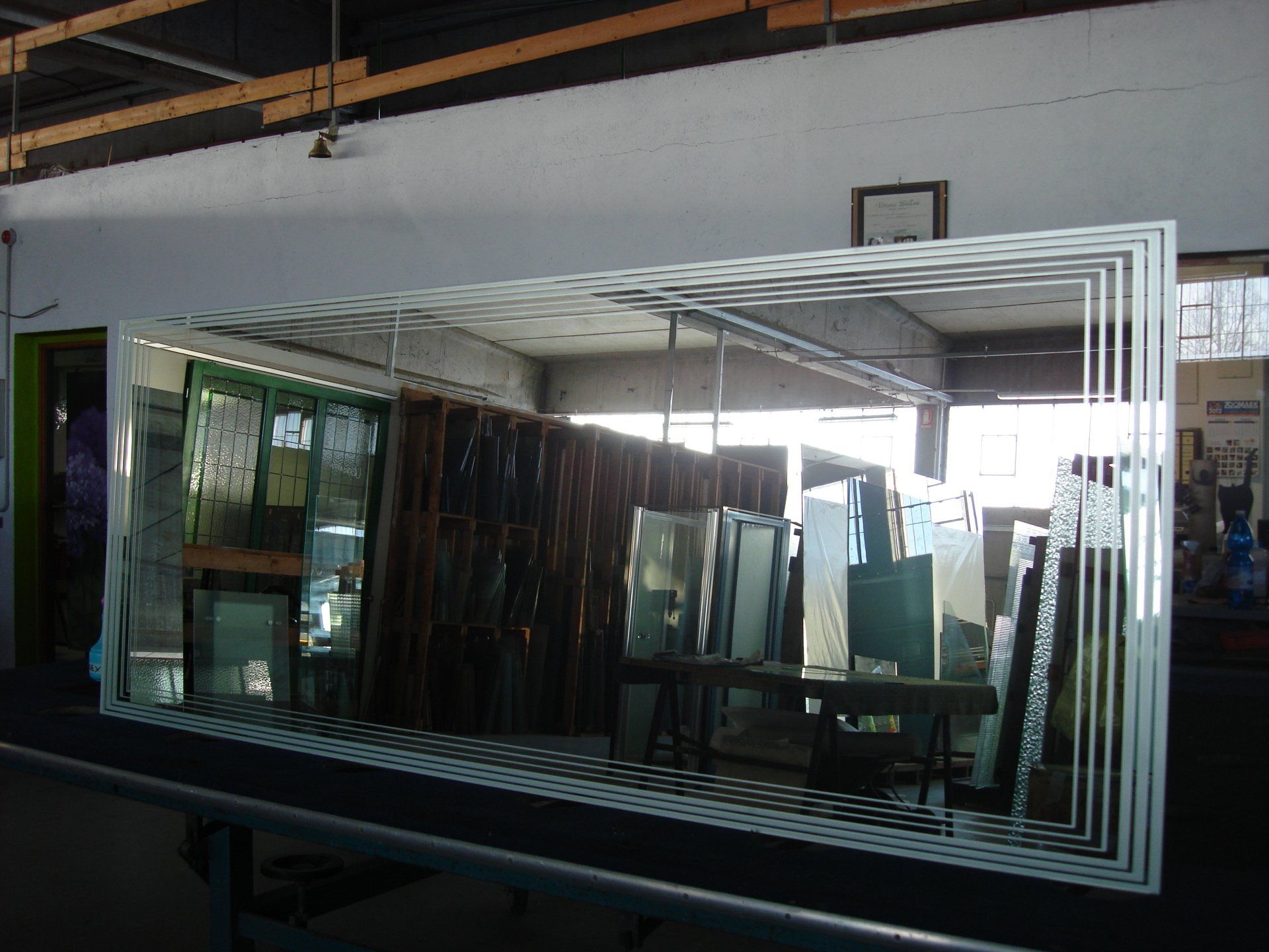 Grande specchio rettangolare con cornice incastonata, che riproduce l'ambiente di un laboratorio.