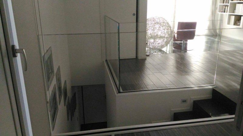 scala in legno scuro con parapetto in vetro