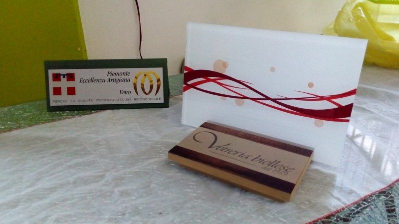 Insegna, invito e scatola verdi e bianchi su una superficie in marmo. Dettagli di colore rosso e marrone.