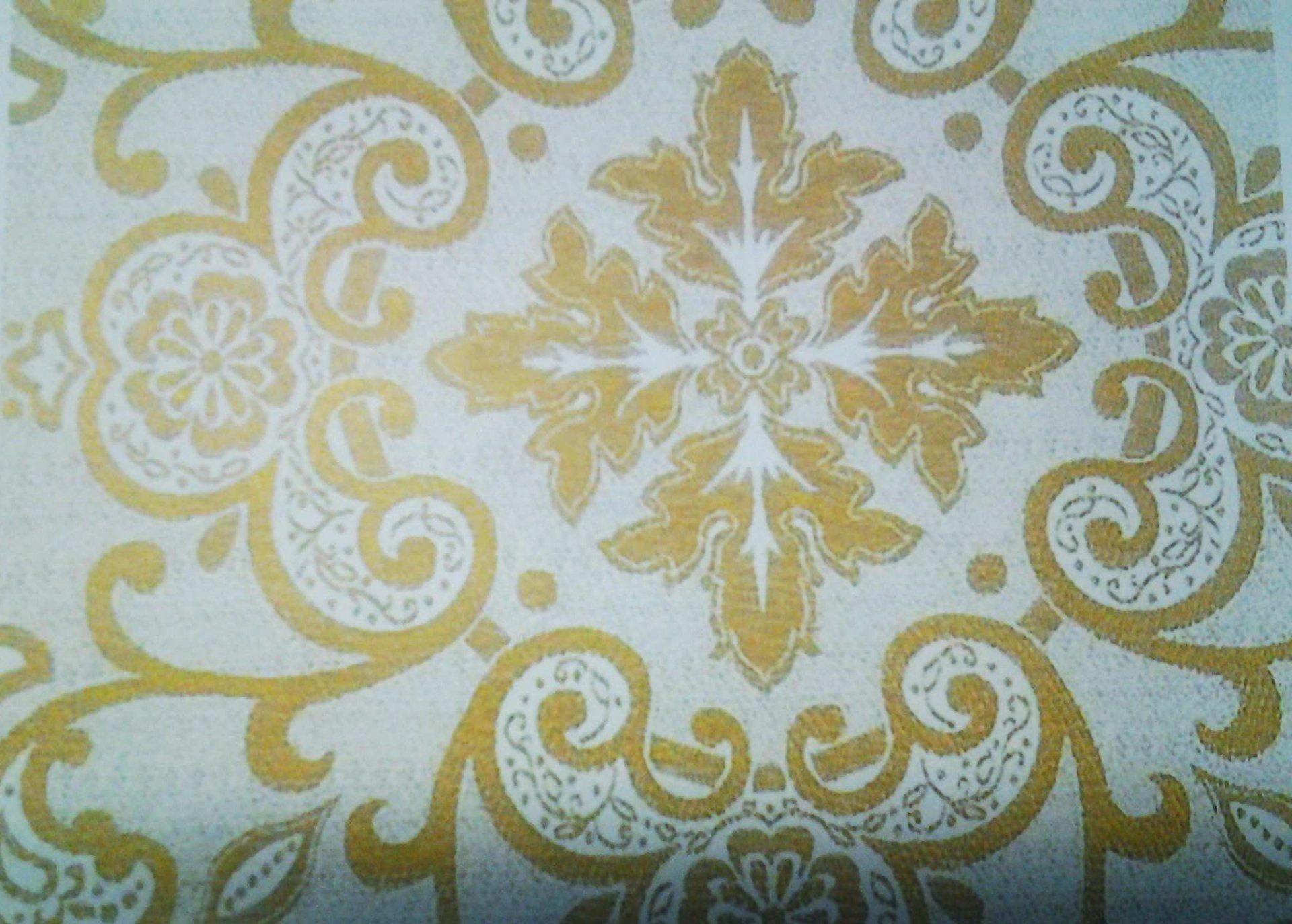 Tessuto color crema con motivo floreale dorato caratterizzato da vortici e un motivo centrale a foglia.