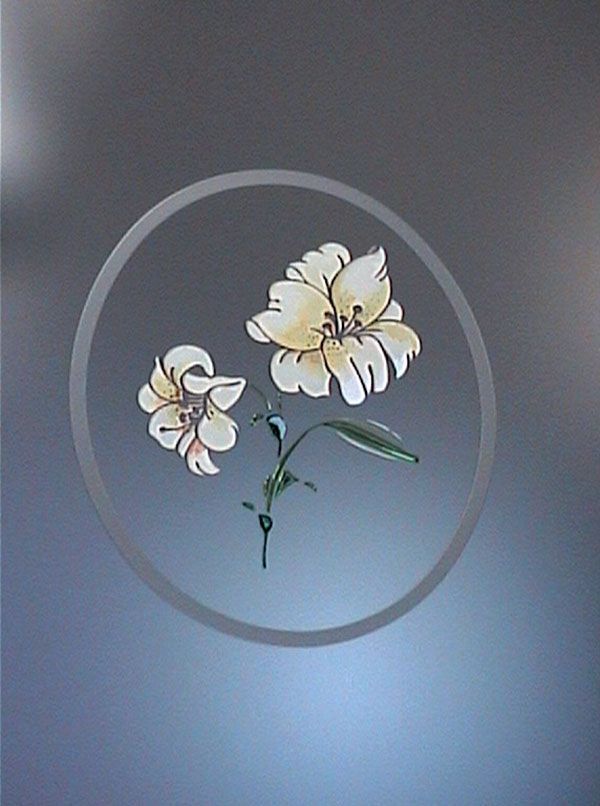 Due fiori di giglio color crema con steli e foglie verdi all'interno di un cerchio grigio su sfondo grigio.