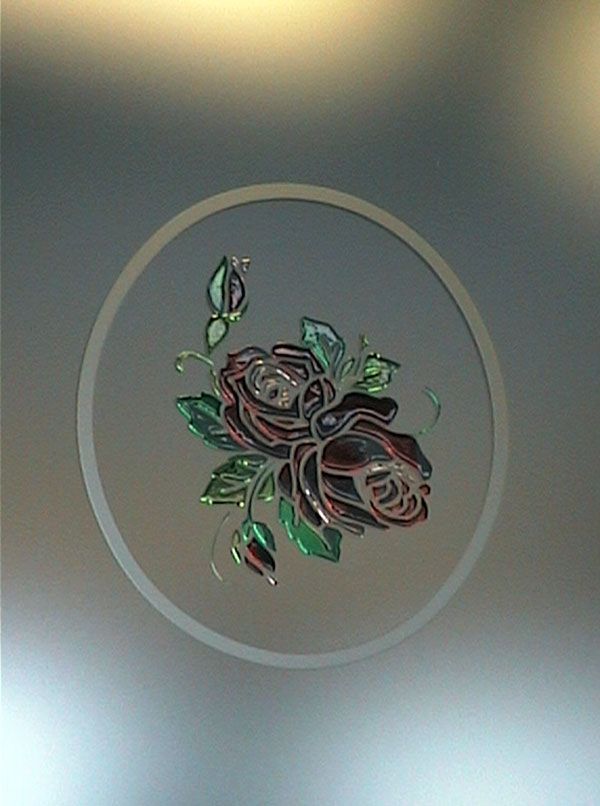 Vetro smerigliato con motivo circolare di rose rosse e foglie verdi.