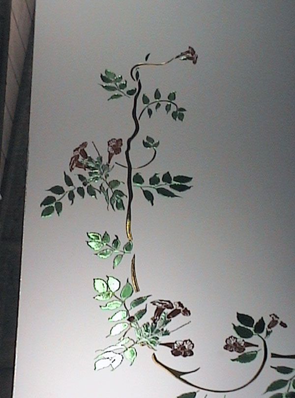 Disegno floreale a forma di vite nei colori verde e bordeaux su una superficie bianca.