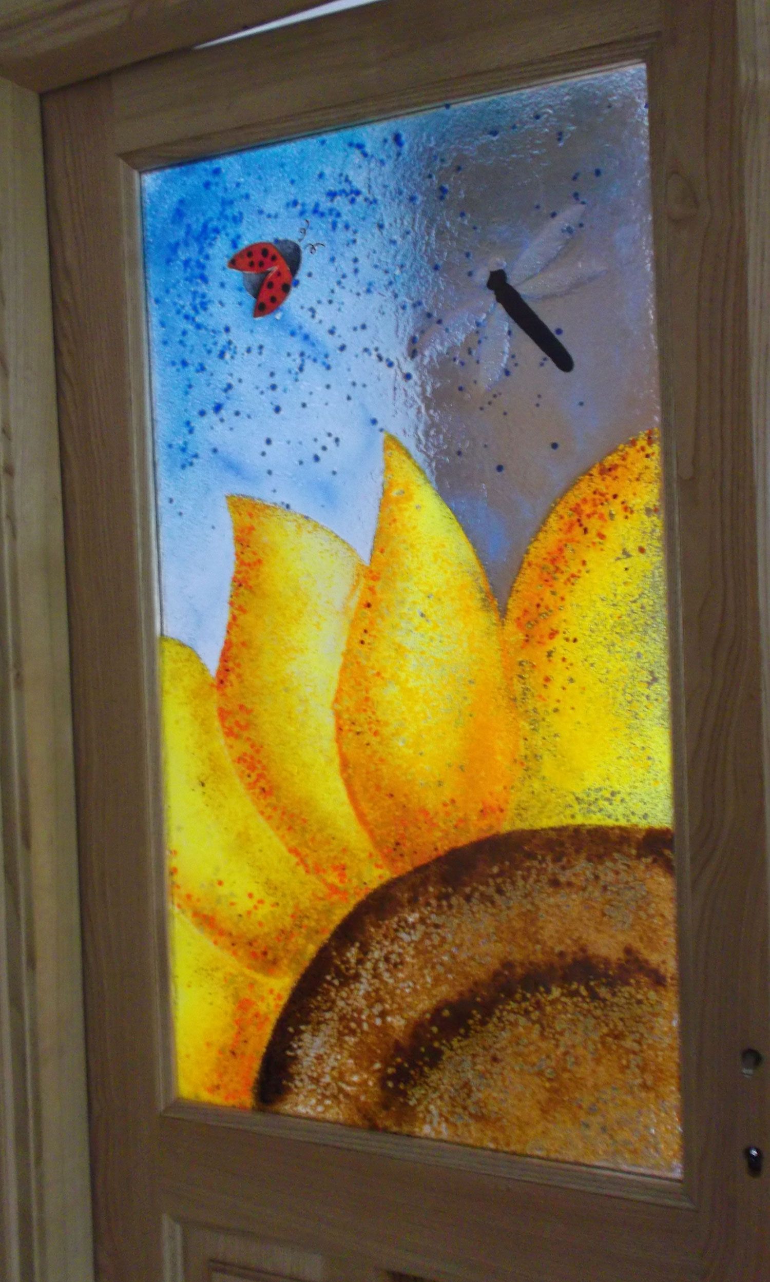 Vetrata con girasole, coccinella e libellula.