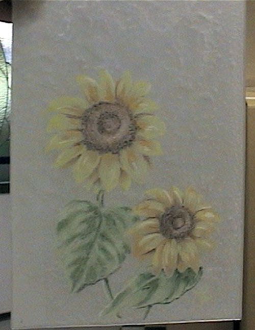 Dipinto raffigurante due girasoli con petali gialli e foglie verdi su sfondo grigio.