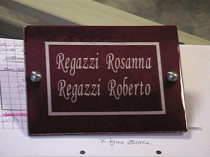 Targhetta rosso scuro con scritte argentate: 