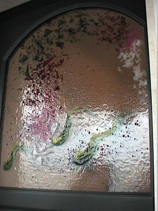 Porta in vetro smerigliato con motivi floreali colorati e a forma di serpente.
