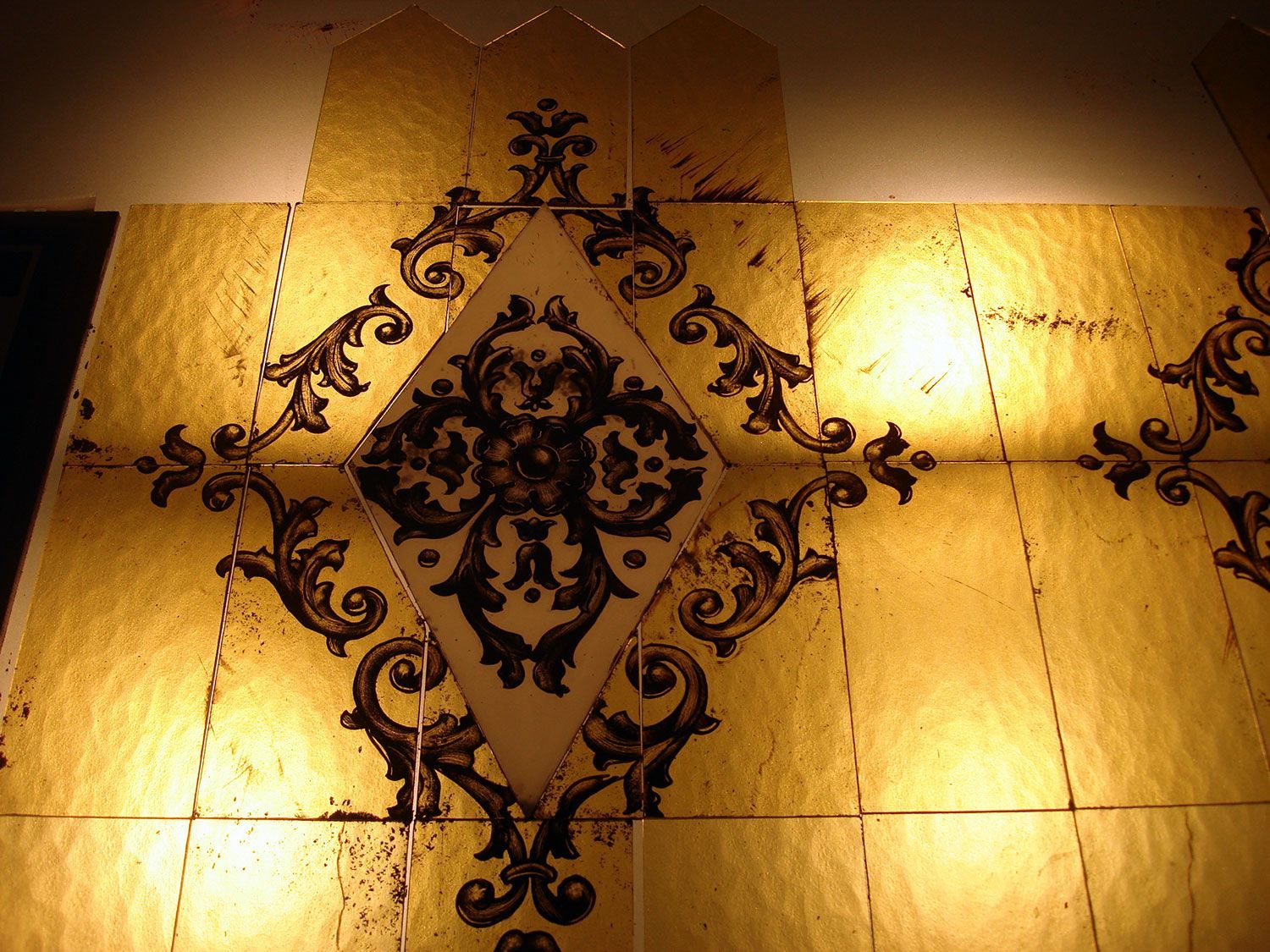 Piastrelle in foglia d'oro con decori neri.