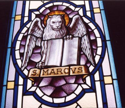 Vetrata raffigurante il leone di San Marco con un libro, un'aureola dorata e uno stendardo.