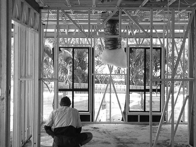 Man is Sitting on the Floor in a Building Under Construction — Proserpine Electrical Services in Proserpine, QLD