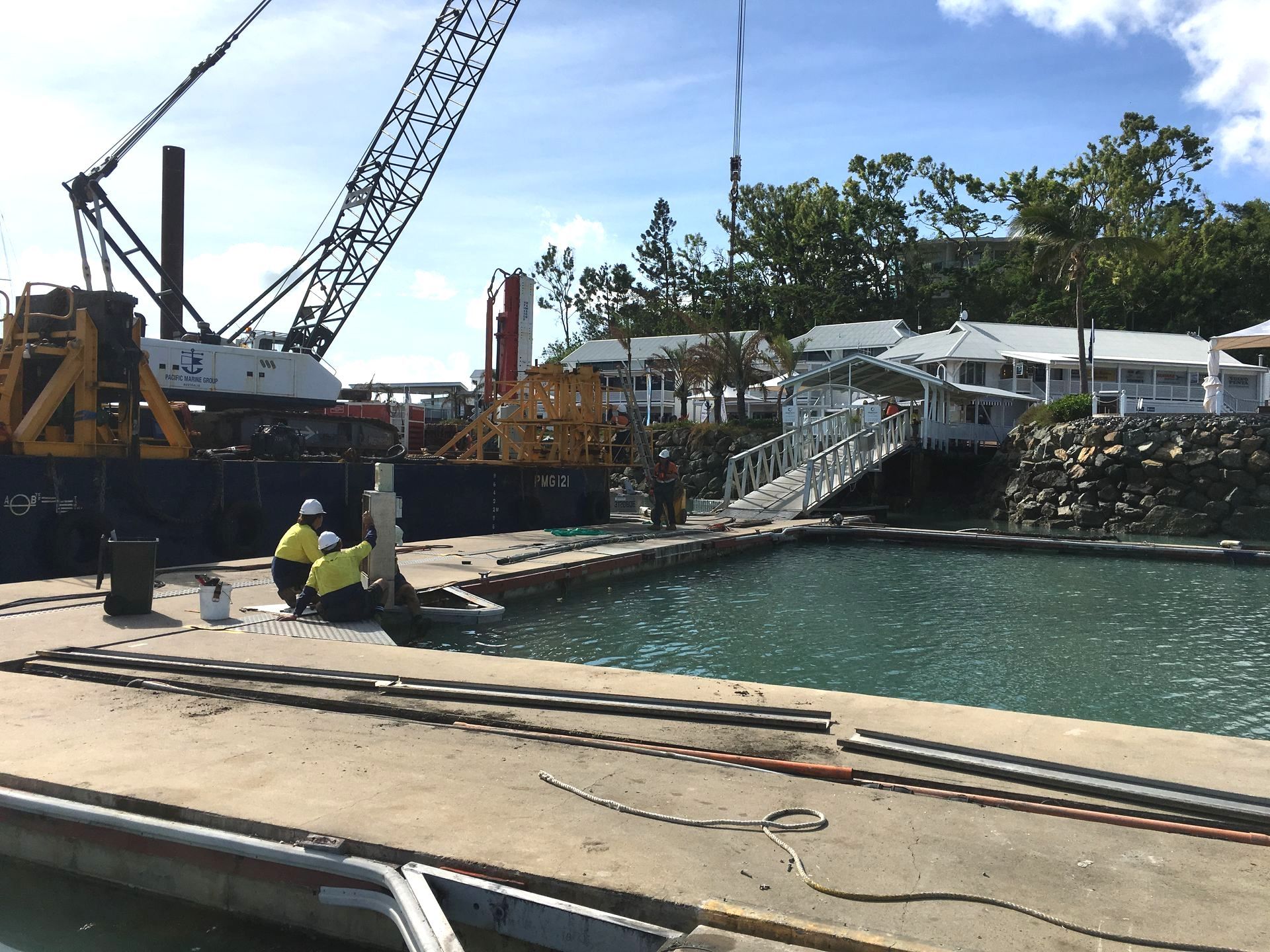 A Couple Electricians are Working on Dock Near the Water — Proserpine Electrical Services in Proserpine, QLD