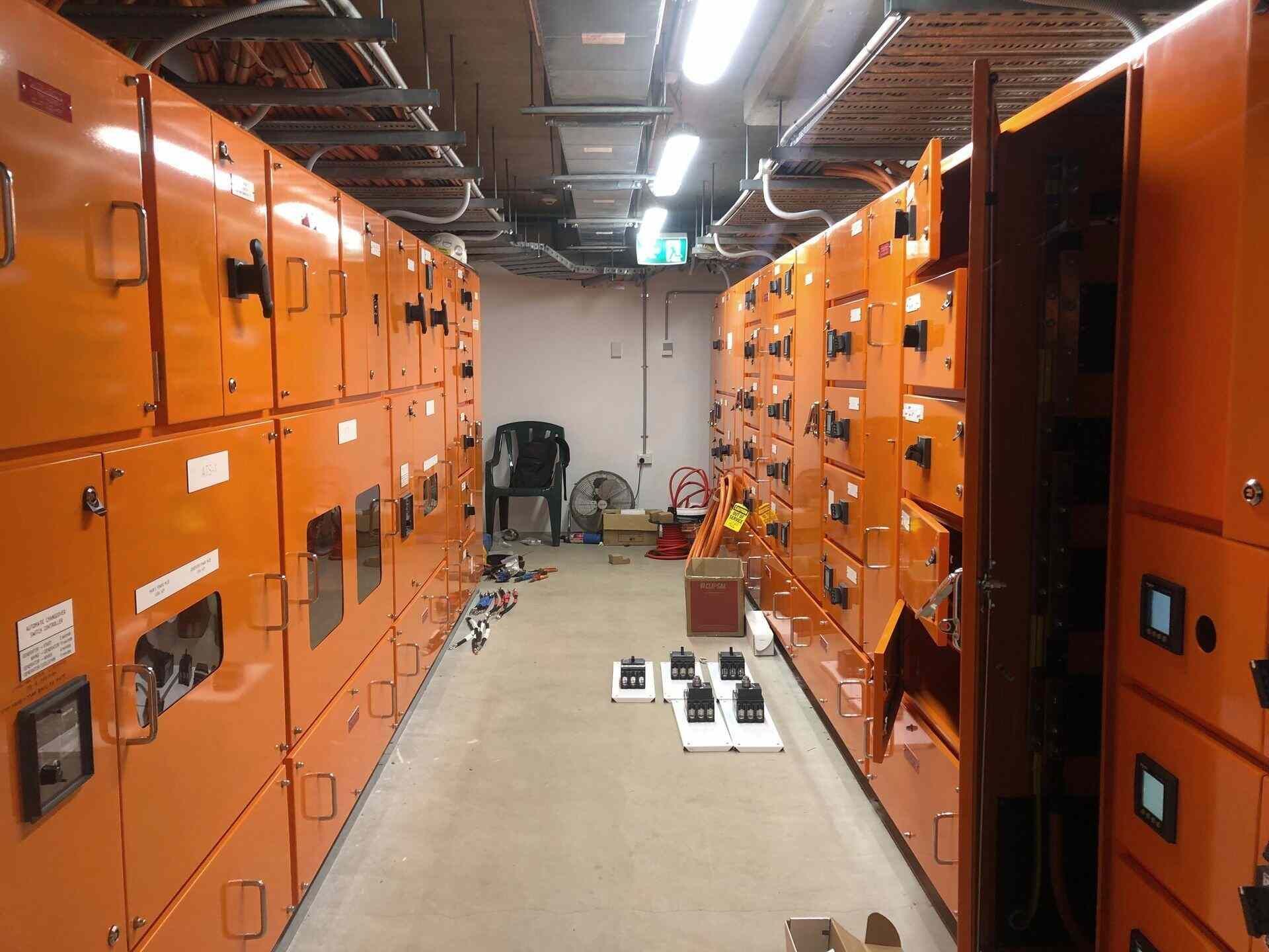 Room Filled With Lots of Orange Electrical Cabinets — Proserpine Electrical Services in Proserpine, QLD