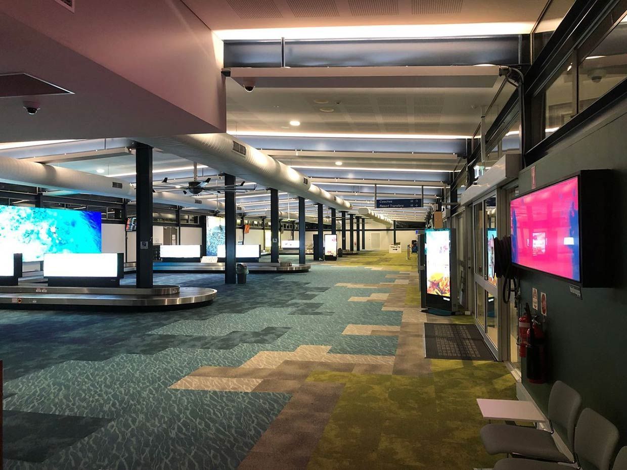 A Long Hallway At An Airport With A Lot of screens on the wall — Proserpine Electrical Services in Whitsundays, QLD