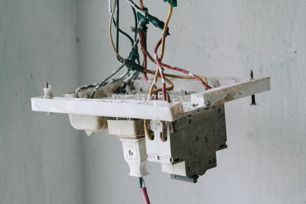 Broken Light Switch With Wires Hanging From It — Proserpine Electrical Services in Proserpine, QLD