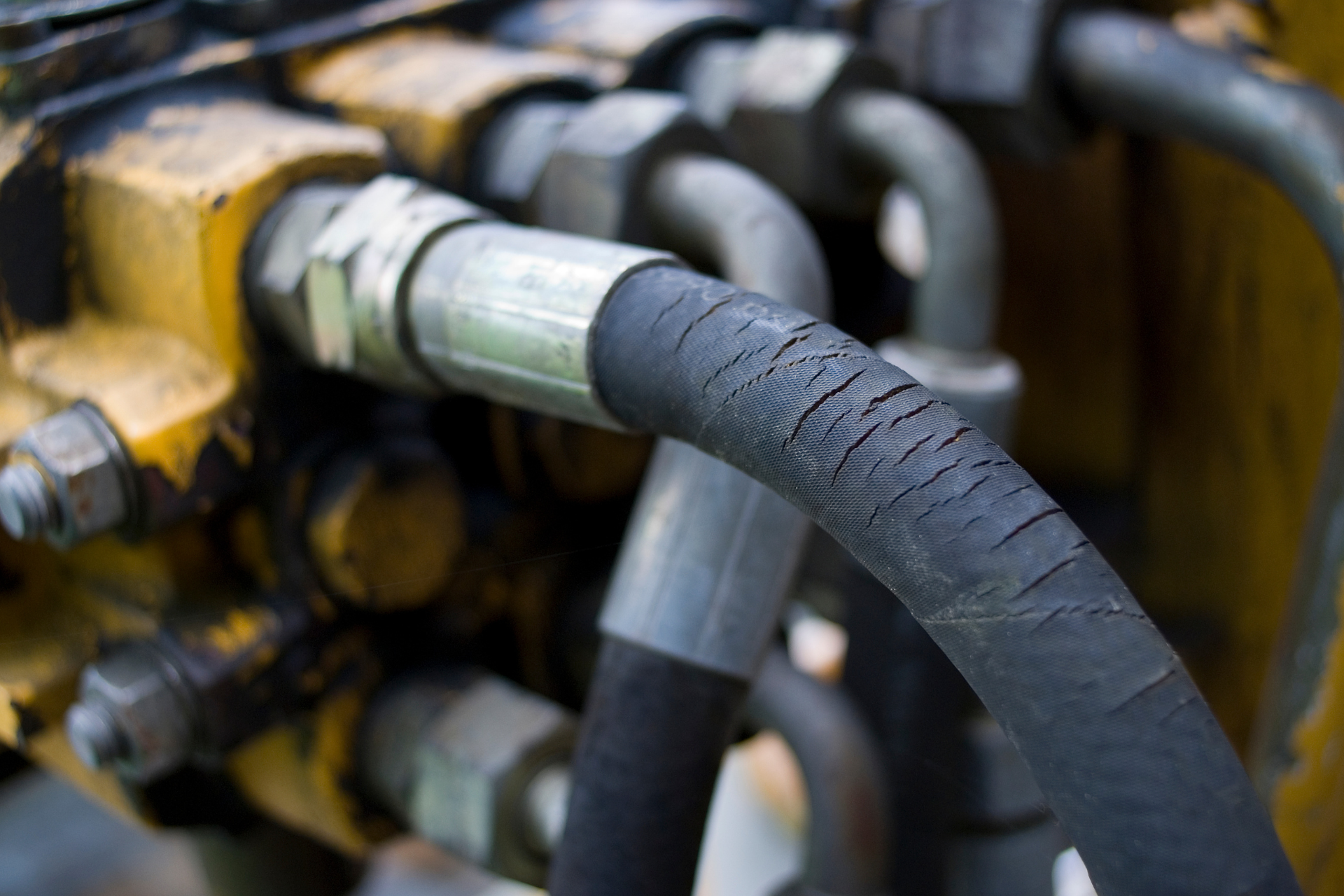 Close-up of hydraulic hoses and metal fittings on industrial machinery