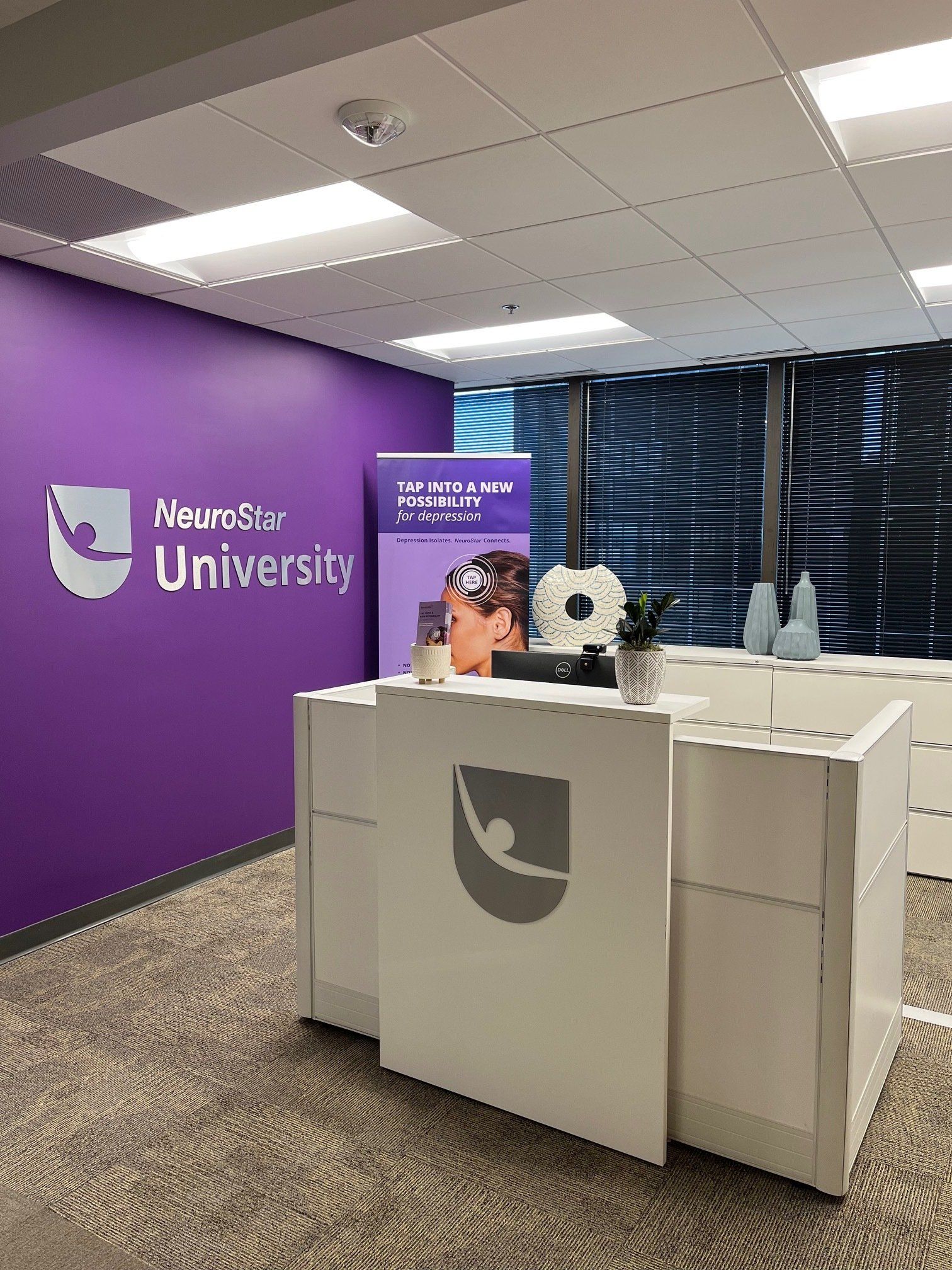 Reception area with purple accents; logo of NeuroStar University visible.