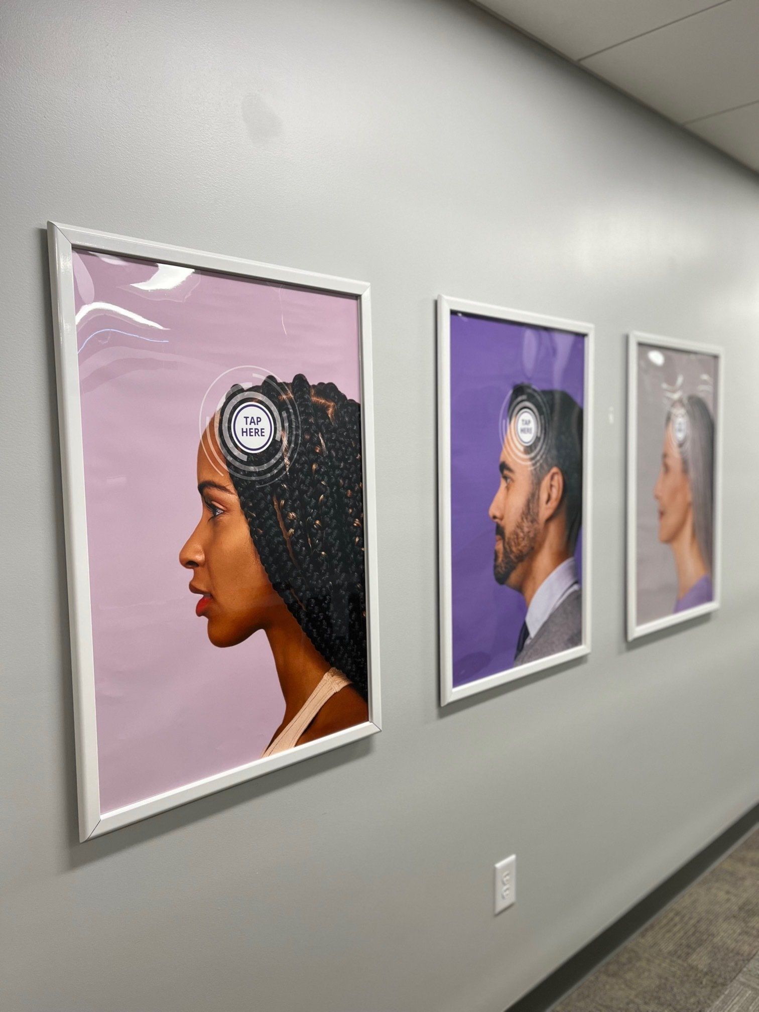 Three framed portraits on a wall: a Black woman, a man, and a woman, all in profile with a glowing circle.