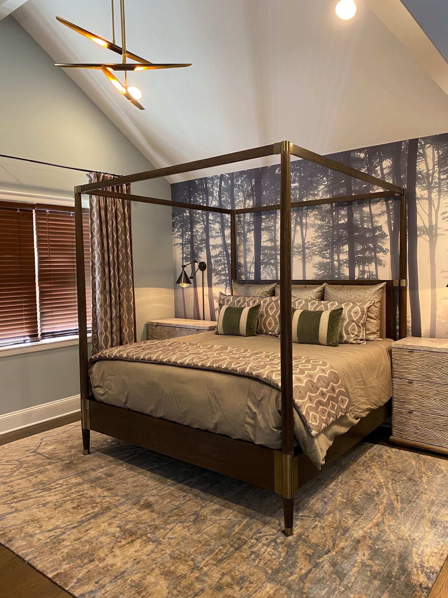 Bedroom with canopy bed, forest mural, and patterned bedding, in neutral tones.